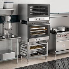 an industrial kitchen with stainless steel appliances and counter tops, including stove top ovens