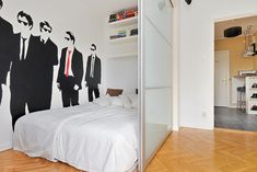 a bedroom decorated in black and white with a wall mural depicting men's suits