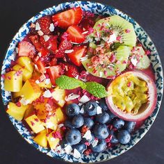 a blue and white bowl filled with fruit