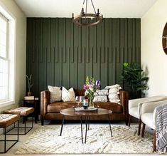 a living room with two couches and a coffee table in front of a green wall