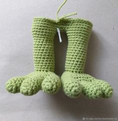 two crocheted green boots hanging from a string