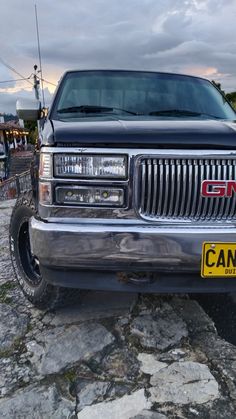 a silver truck parked on top of a rocky road