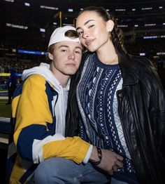 a man and woman sitting next to each other at a football game