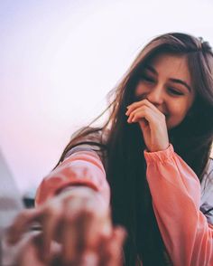 a woman holding her hand up to her face