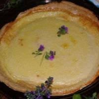 there is a pie with flowers on the top of it and purple flowers in the bottom