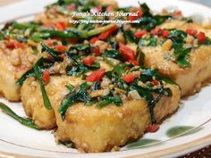 some food is on a white plate with green and red peppers in the top half