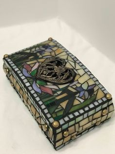 a stained glass box sitting on top of a white table