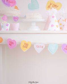 there are many hearts hanging from the ceiling in front of cakes and cupcakes