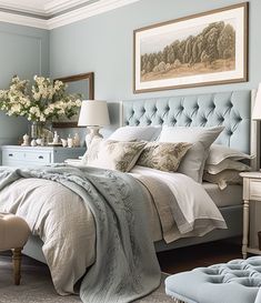 a bedroom with blue walls, white bedding and an upholstered headboard