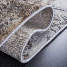 a close up view of a rug on top of a wooden table with a black surface