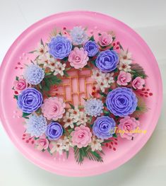 a pink plate with purple and blue flowers on it