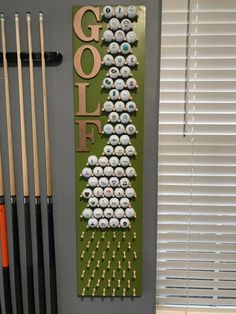 a golf themed wall hanging on the side of a door with cues and balls in it