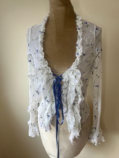 A Y2K coquette white and blue floral mesh blouse with frills and a lace up ribbon front. UK Size 8. Please check measurements: Chest - 84cm Waist - 65cm Length - 54cm Blouse With Frills, Frilly Shirt, Coquette White, Lace Up Shirt, Shirt Coquette, Frilly Blouse, Frill Blouse, Laced Up Shirt, Blouse Lace