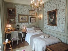 a bedroom with floral wallpaper and chandelier