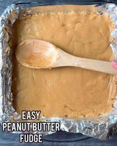 a pan filled with peanut butter fudge and a wooden spoon on top of it