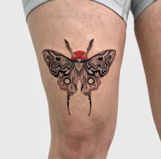 a woman's thigh with a butterfly tattoo on her leg and an eyeball in the middle