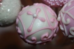 some pink and white cake balls on a table