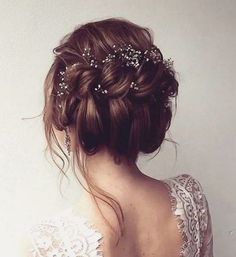 the back of a woman's head wearing a bridal hair piece with pearls on it