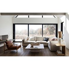 a modern living room with large windows and wooden flooring is featured in this image