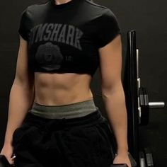 a woman in black shirt and shorts holding a barbell