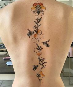 the back of a woman's body with flowers and bees on it