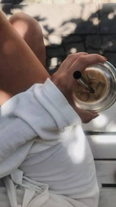 a person sitting on a bench holding a bowl with something in it