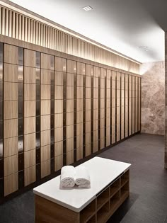 an empty room with wooden lockers and towels on the table in front of it