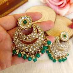 A pair of Golden Wedding Green Chandbali Earring with embedded stones. Size & Other Details Length : 7cm Weight : 20gm/pc Material : Alloy, Pearl, Stone Shape : Drop Shape Attire : Lehenga, Salwar Suit, Kurti, Saree, Flared Dress Traditional Green Hoop Earrings For Wedding, Green Chandbali Hoop Earrings For Wedding, Chandbali Jeweled Temple Jewelry Bridal Earrings, Jeweled Chandbali Bridal Earrings In Temple Jewelry Style, Jeweled Chandbali Bridal Earrings In Temple Style, Jeweled Chandbali Temple Jewelry, Jeweled Chandbalis For Festivals, Jeweled Chandbali Earrings For Wedding, Traditional Jeweled Round Bridal Earrings