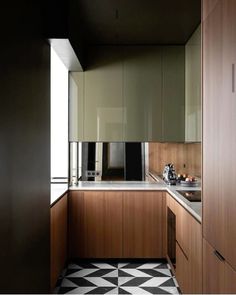 a kitchen with black and white checkered flooring next to a wall mounted oven