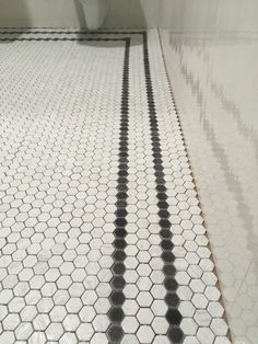 a white tiled floor with black and white hexagonal tiles on the bottom half