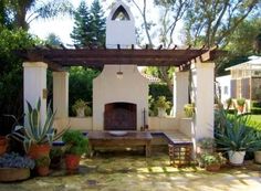 an outdoor patio with a fireplace and potted plants