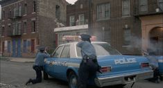 two police officers standing next to a cop car