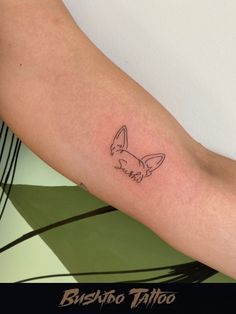 a tattoo on the arm of a person with a bunny ears head and name in black ink