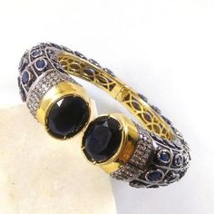 This Listing is for 1 Piece Beautiful Black Onyx, Sapphire & CZ Hydro Gemstone 24k Gold Plated Cuff Bangle Bracelet Jewelry Gemstone: Black Onyx, Sapphire & CZ Metal : Brass Style : Cuff Bracelet Size : Cuff Adjustable Size Plating : 24k Gold Plated & Black Oxidize Color : Yellow,White, Black Note : We Ship Parcel Via India Post Economy Shipping It's Take 20 To 25 Days To Arrive. Check my other items frequently. I will be adding to the inventory regularly. Be sure to visit my shop to Formal Gemstone Cuff Bracelet In Bangle Shape, Formal Gemstone Bangle Cuff Bracelet, Jeweled Round Bangle For Anniversary, Formal Jeweled Round Bangle, Round Gemstone Bangle For Party, Hand Set Round Cuff Bracelet For Anniversary, Jeweled Bangle Cuff Bracelet As Gift, Jeweled Cuff Bangle Bracelet For Gift, Formal Jewel Bangle Cuff Bracelet