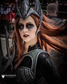 a woman with red hair and makeup is dressed up as a female warrior in costume