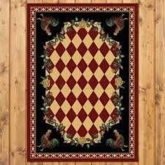 a red and black area rug hanging on a wooden wall