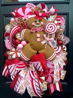 a christmas wreath decorated with gingerbreads, candy canes and a teddy bear