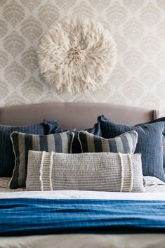 a bed with blue and white pillows on top of it