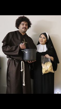 a man and woman dressed up as jesus and mary holding bread in front of a white wall