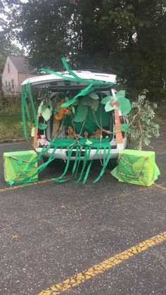 the back end of a van is decorated with green leaves and plastic wrap around it