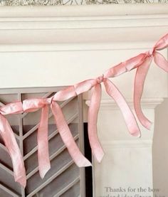 a pink ribbon hanging from a fireplace mantel