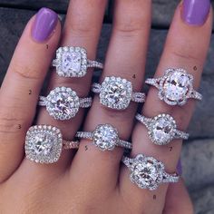 a woman's hand with five different engagement rings on it and purple nail polish