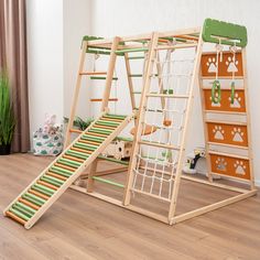 a child's wooden swing set with green and orange accessories on the bottom floor