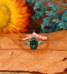 a close up of a ring on top of a leaf with flowers in the background