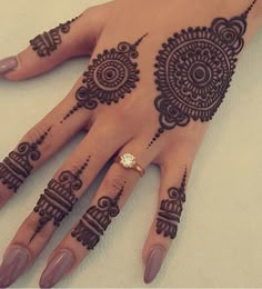 a woman's hand with henna tattoos on it