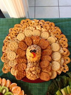 a turkey made out of crackers sitting on top of a table next to fruit