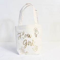 Details Product Detailsthe Flower Girl Can Hold All Of Their Flower Petals In A Metallic Gold Flower Girl Bag! This White Jute And Cotton Bag Features A Metallic Gold "Flower Girl" Headline And Metallic Gold Flower Designs. You Can Put The Flower Petals Inside This Bag For The Flower Girl. Watch The Flower Girl Shine As They Walk Down The Aisle With This Bag! 8in Wide X 3in Long X 7 1/2in Tall Attached Handles, 5in Drop Length New With Tags;Never Used Gold Bucket Bag For Spring, Gold Bags For Spring Gift, Cute Gold Bags For Everyday Use, Cute Gold Bag, Cute Flower-shaped Bags For Spring, Cute Flower-shaped Bag For Spring, Cute Flower-shaped Spring Bag, Flower Girl Gift Bag, Gold Flower Girl