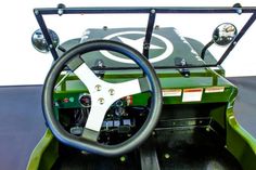 the inside of a green golf cart with steering wheel