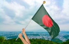 a person holding a flag on top of a hill