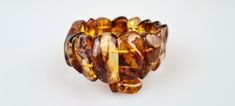 Welcome to my gemstone shop. I guarantee that all my items are handmade by me and made of genuine natural real Baltic Amber gemstone. This raw Amber bracelet is handmade of genuine brown-cognac color Amber gemstone.  It is a bit elastic.  It will be just a stunning gift for a sister, mother or grandmother...   Very raw Baltic Amber. All natural Parts.  Made on two elastic strings.  All amber beads are processed in such a way that their natural shape and color remain as much as possible. The brac Brown Bangle Bracelet For Gift, Brown Bangle Bracelet Gift, Brown Gemstone Bracelets For Healing, Brown Gemstone Healing Bracelets, Brown Bracelets With Natural Stones, Unique Brown Bracelets With Natural Stones, Elegant Handmade Brown Stretch Bracelet, Brown Gemstone Bracelets, Brown Gemstone Round Bracelets